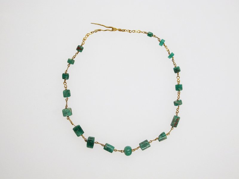 Gold chain necklace on a pale background